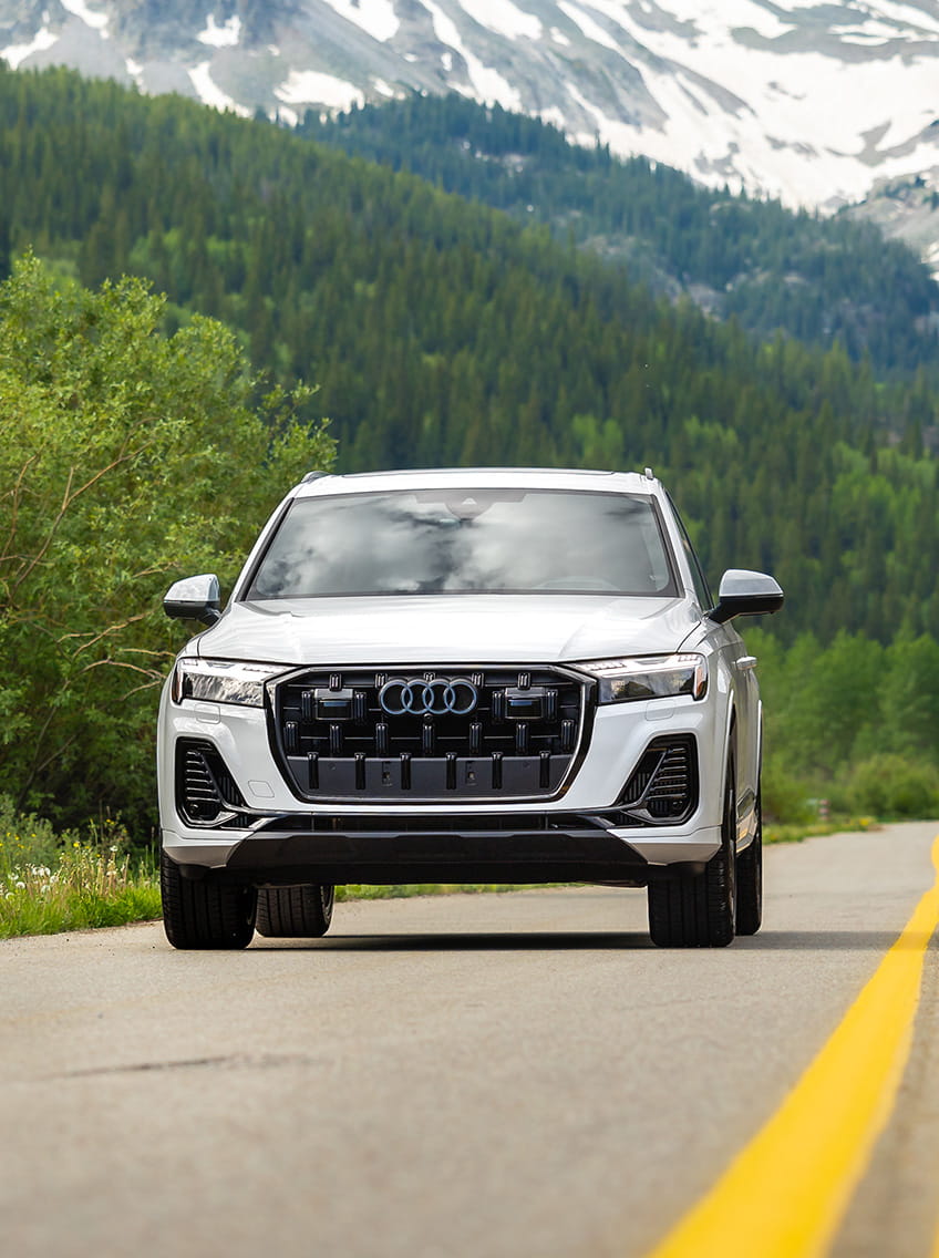 audi car driving on road in front of mountains